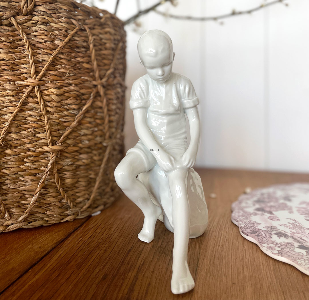 Dreng siddende på sten, Royal Copenhagen figur nr. 520