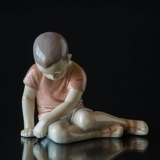 Boy sitting sadly looking at the ground i brown shirt, Bing & Grondahl figurine no. 1671