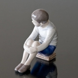Boy sitting on books, Little professor, Bing & Grondahl figurine No. 1742