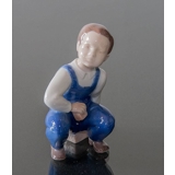 Boy sitting with dice ready to play the game, Bing & Grondahl figurine No. 2402