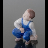 Boy sitting with dice ready to play the game, Bing & Grondahl figurine No. 2402