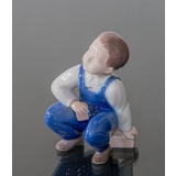 Boy sitting with dice ready to play the game, Bing & Grondahl figurine No. 2402