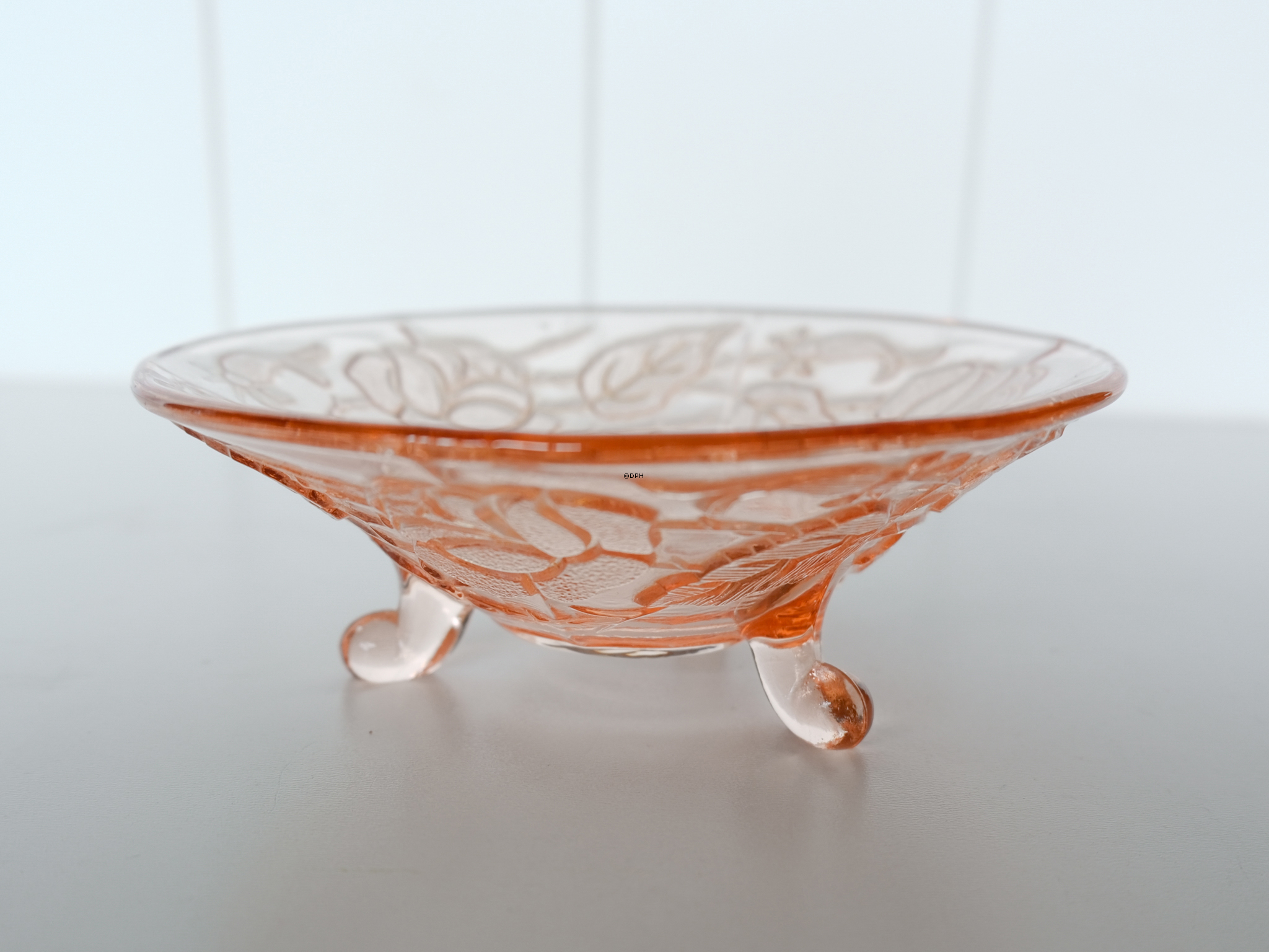 Glasskål med slibninger af blomster i rosafarvet glas