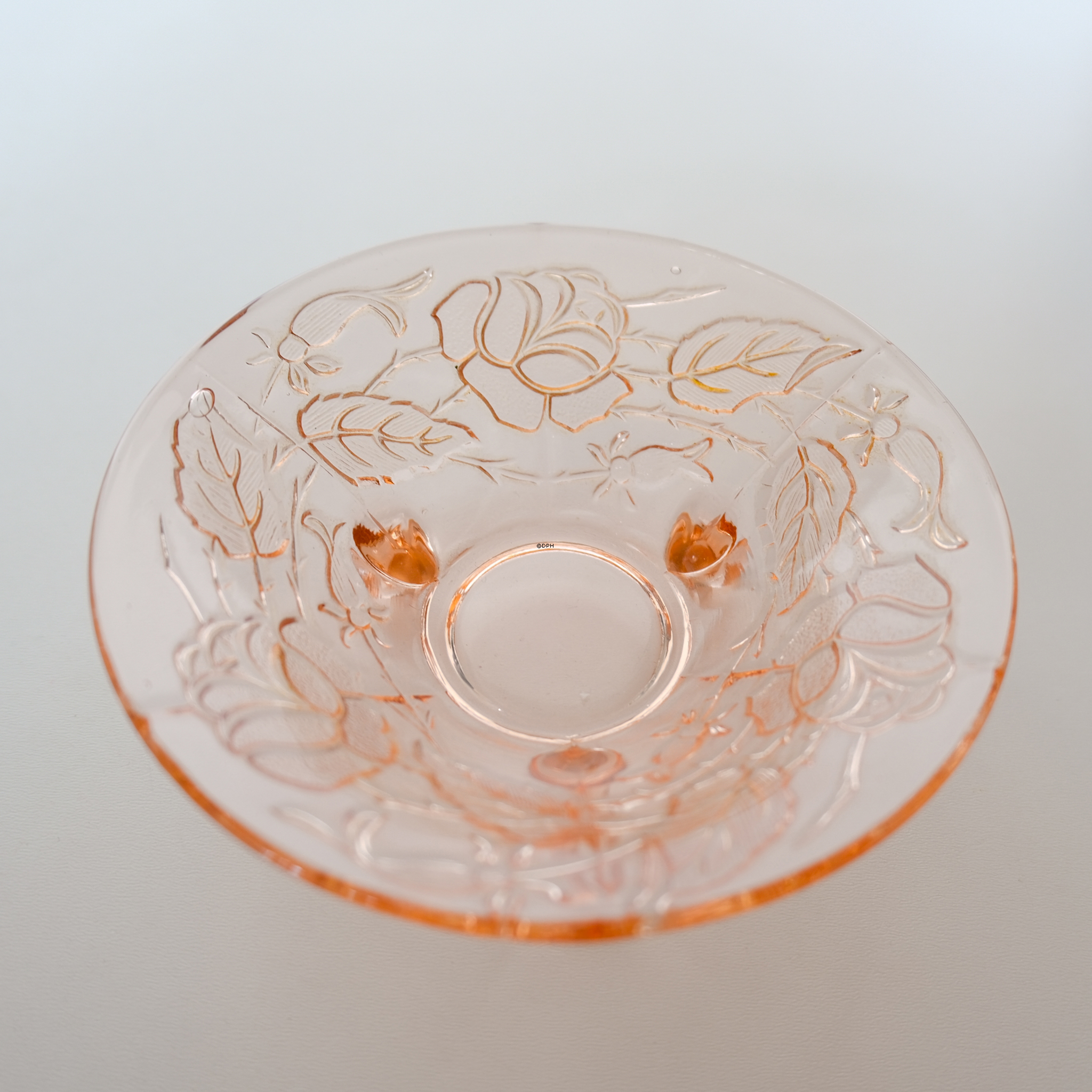 Glasskål med slibninger af blomster i rosafarvet glas
