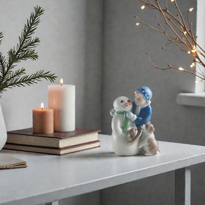 Royal Copenhagen figuren Else bygger snemand står på en skænk med gran i vase, levende lys og små varme julelys.