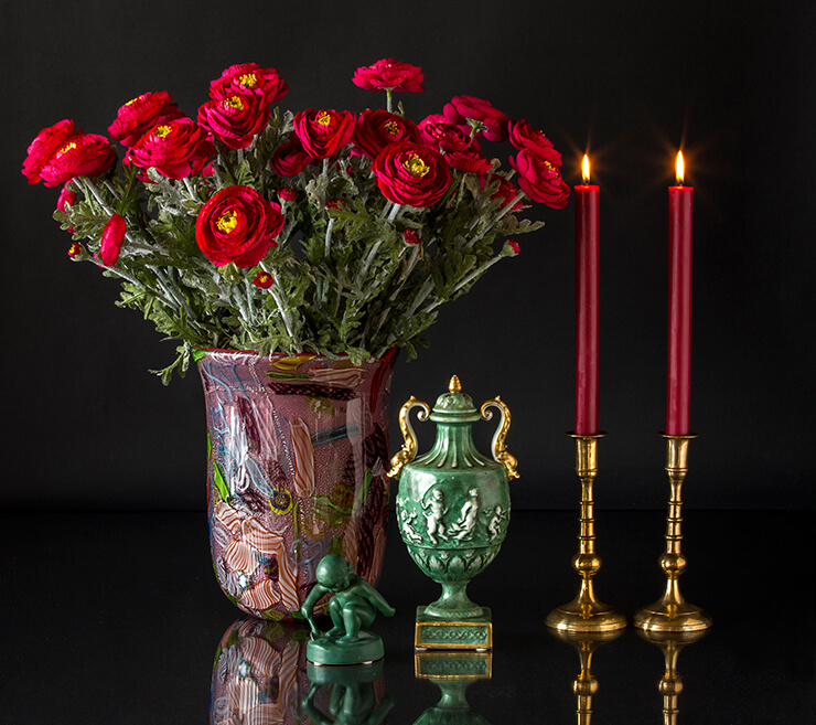 Glass art vase with green figurine and vase together with two brass candlesticks