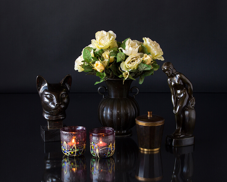 Black figurines of woman and cat's head with black vase and glass tealight candleholders