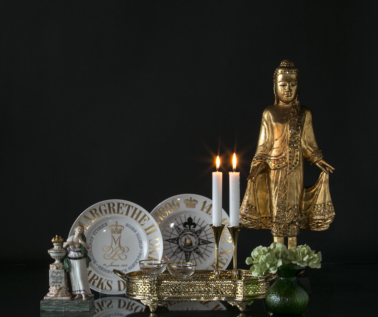Buddha flankeret af mindeplatter og venskabsfigur bagved bakke med Asmussen lysestager