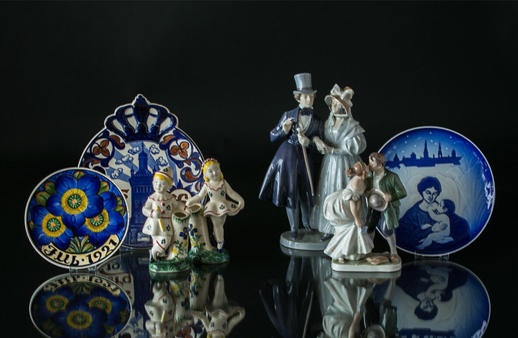 Aluminia Child welfare figurines and plates next to Royal Copenhagen figurines and plate