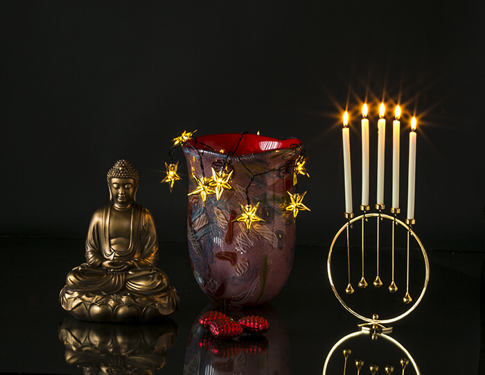 Stor buddha sammen med rød glasvase og Asmussen lyseholdere på rund opsats