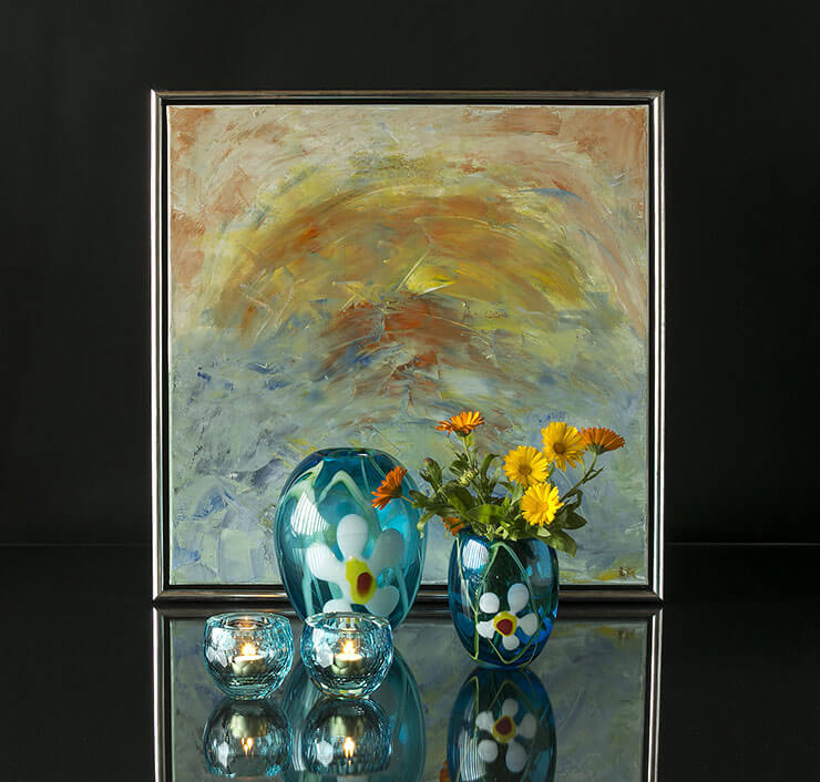 Glasvasen mit Blumen und Teelichthalter