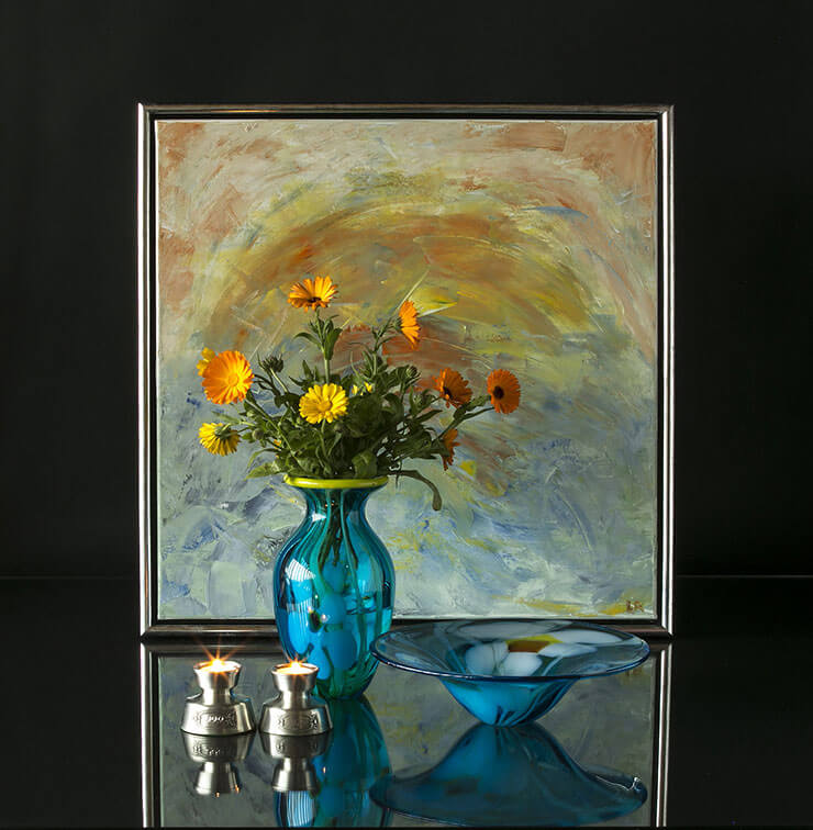 Glass vase and bowl with flowers and tin candleholders
