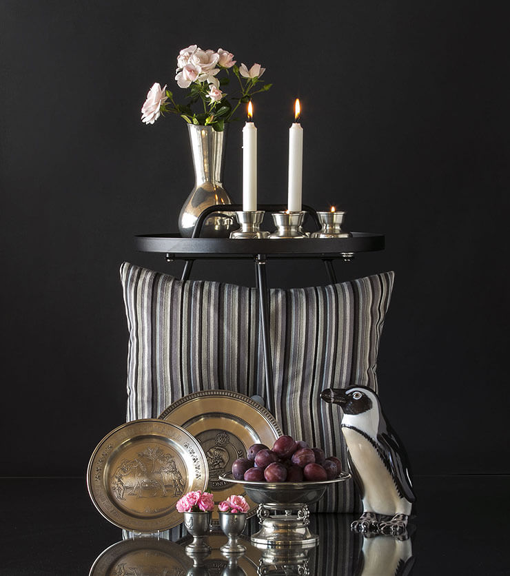Pewter tin vase with tin candlesticks, tin plates and tin egg cups and a penguin figurine