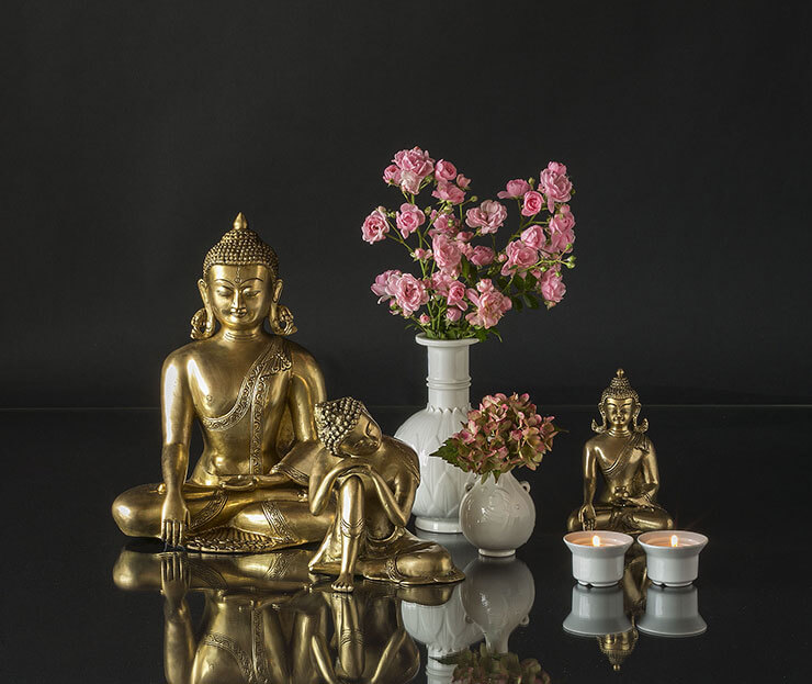 Buddha figurer i lille opstilling med vaser og fyrfadslys