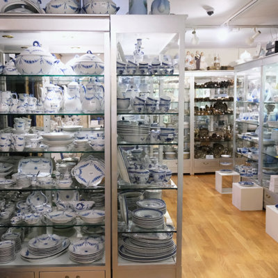Glasmontre hos DPH Trading i Odense N med blåt og hvidt porcelæn fra Royal Copenhagen og Bing & Grøndahl – herunder Musselmalet, Tranquebar og Empire-stel