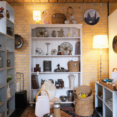 Indgangsområde i DPH Tradings butik i Odense med udstilling af figurer, platter, glas, lamper, fade og kurve – en inspirerende og hjemlig opstilling, hvor nyt og gammelt er kombineret for at skabe varme og hygge