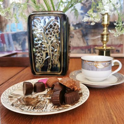 Egemose Fars Dag platte brugt som kagetallerken med chokolade, kombineret med Magnolia kaffekop og vase med dekoration i baggrunden.