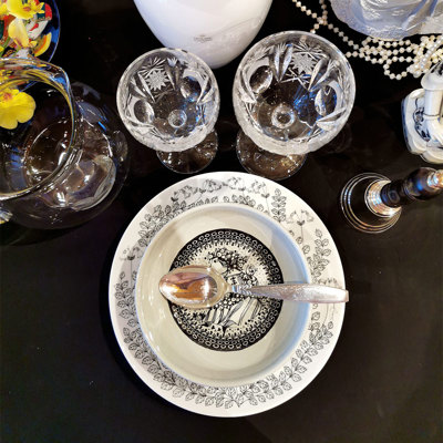 Borddækning i sort og hvid med Gustavsberg platte og Bjørn Wiinblad skål, kombineret med krystalglas og sølvbestik.