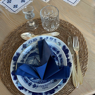En charmerende juleborddækning i blå og hvid, kombineret med guld bestik og blå serviet.