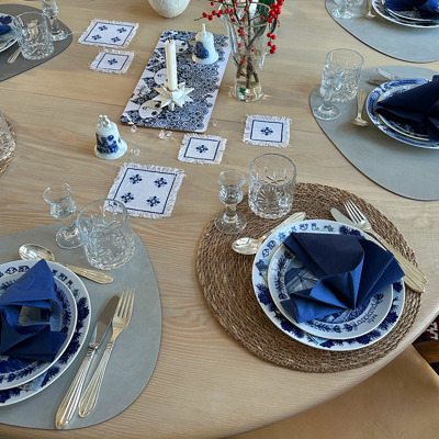 Julefrokost borddækning med Jenny Nystrøm juletallerken til hovedret og Seltmann svensk landskabsplatte til forret. Opdækning i blå og hvide nuancer med serviet og krystalglas.