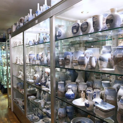 Store glasmontre hos DPH Trading i Odense N fyldt med vaser og porcelæn fra Royal Copenhagen, Bing & Grøndahl og Lyngby Porcelæn – mange med håndmalede motiver